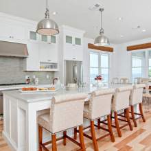 A cozy and functional kitchen with a center island, dining table, and various appliances and items.