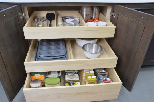 A well-organized kitchen cabinet containing six bowls and three plates neatly arranged on the shelves.