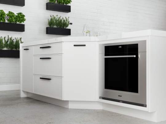 This modern white kitchen features a stylish stainless steel oven, as well as several potted plants creating a pleasant, inviting atmosphere.